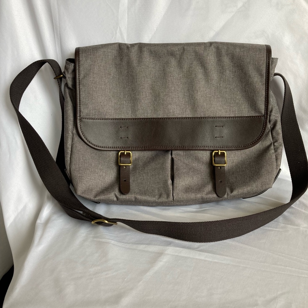 Fossil men’s messenger bag in textile fabric with leather trim.